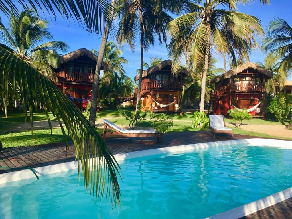 een resort met een zwembad en palmbomen bij Pousada Pais Tropical in Icaraí