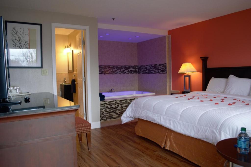 Habitación de hotel con cama grande y bañera en Carrier Motor Lodge, en Newington