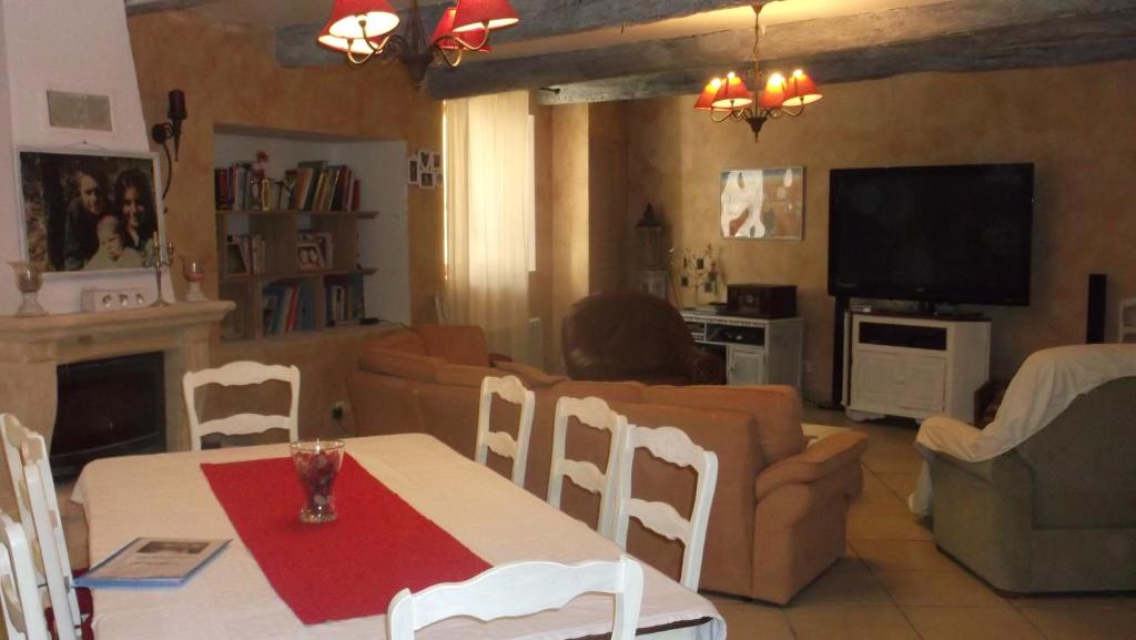 een woonkamer met een tafel en een bank bij La Grange d'Antan in Cruzy