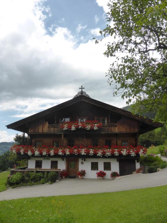 Un bâtiment avec des fleurs à l'avant dans l'établissement Heachhof, à Alpbach