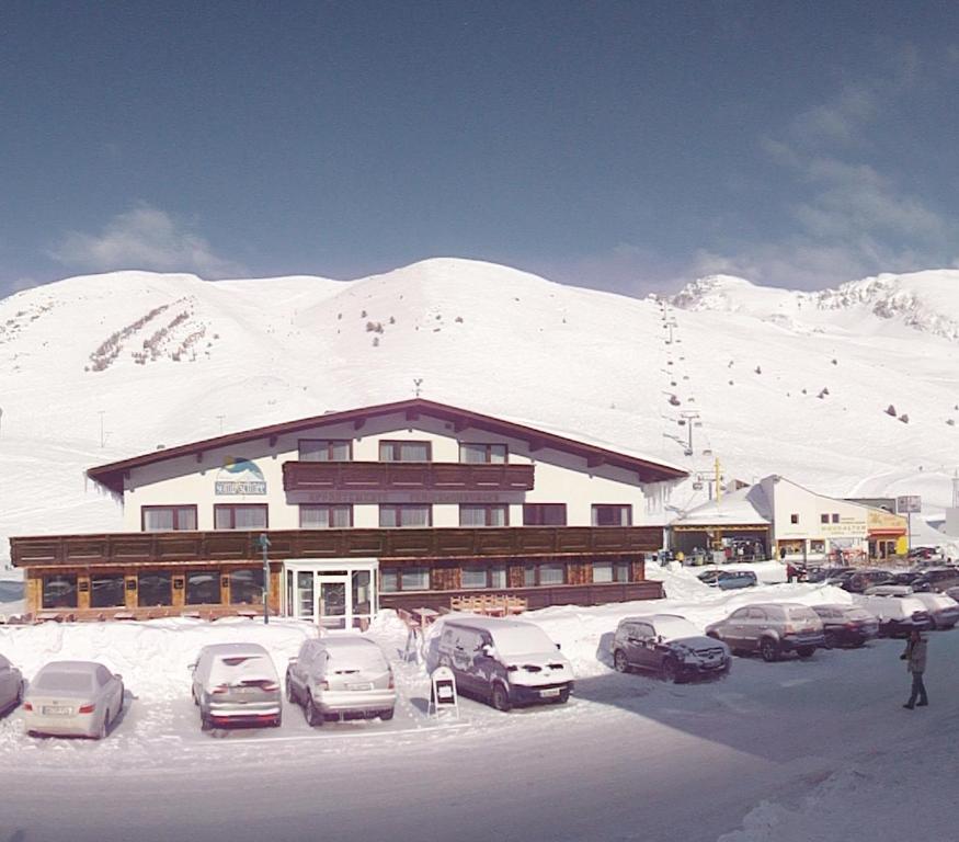 キュータイにあるSonne & Schnee in Kühtaiの雪上駐車場に車を停めた建物