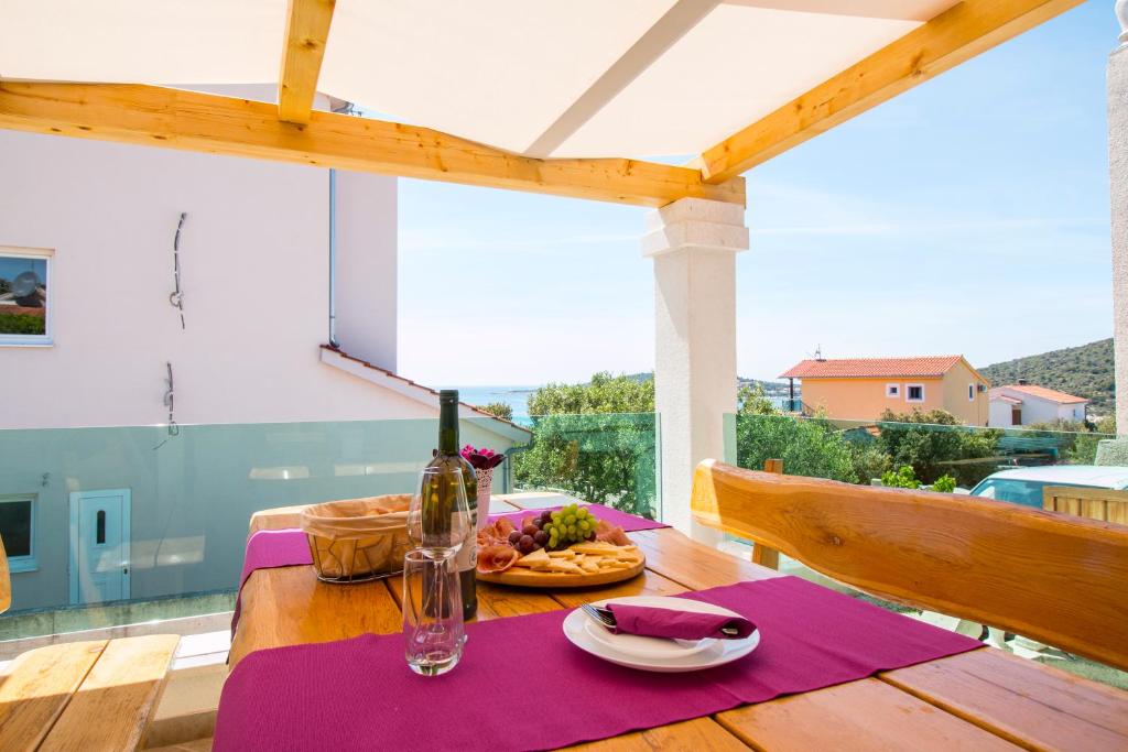 uma mesa com um prato de comida e uma garrafa de vinho em Holiday Home Sevid em Sevid
