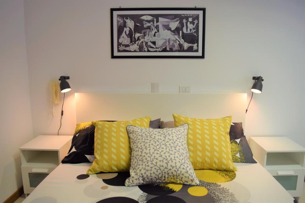 una camera da letto con letto e cuscini gialli di Casa Vacanze Rosalia - affitto breve a Santo Stefano di Camastra