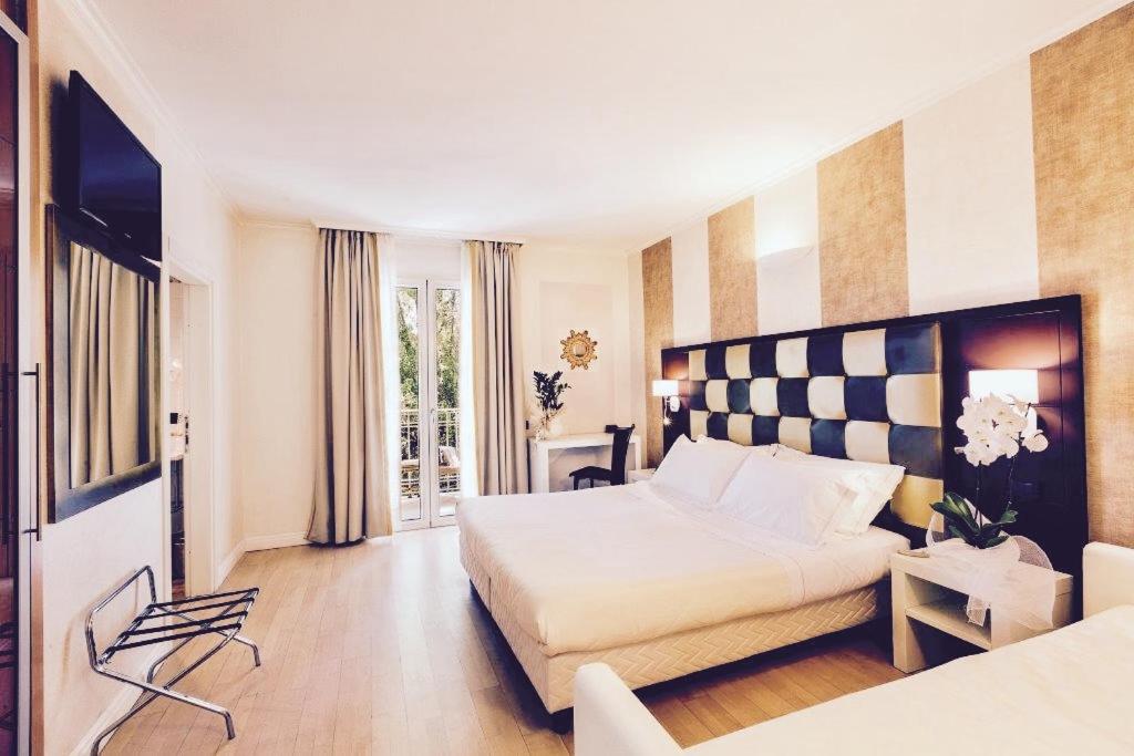 una camera d'albergo con letto e TV di JR Resort Logos Forte dei Marmi a Forte dei Marmi
