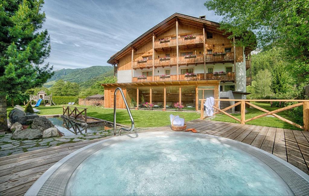 a house with a swimming pool in front of a house at Apartments & Wellness Löfflerblick in Cadipietra