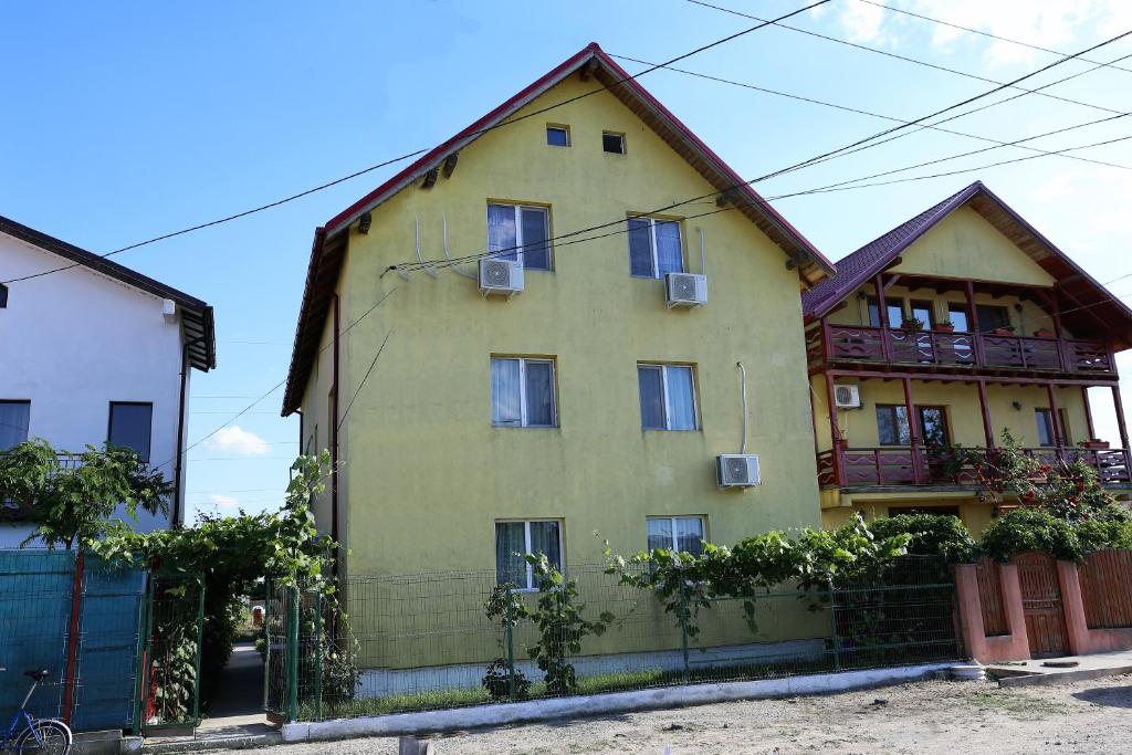 una casa gialla con una recinzione di fronte di Casa Iustina Sulina a Sulina