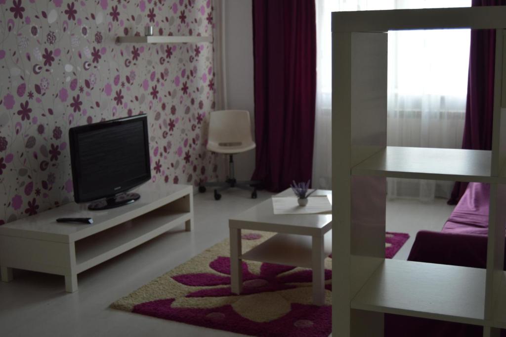 - un salon avec une télévision, un canapé et une table dans l'établissement Apartament Faleza Nord, à Constanţa