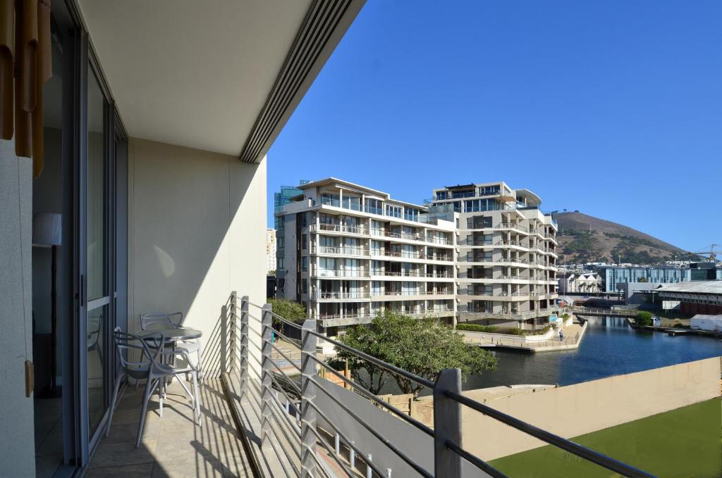 einen Balkon mit Blick auf den Fluss und die Gebäude in der Unterkunft 214 Harbour Bridge in Kapstadt