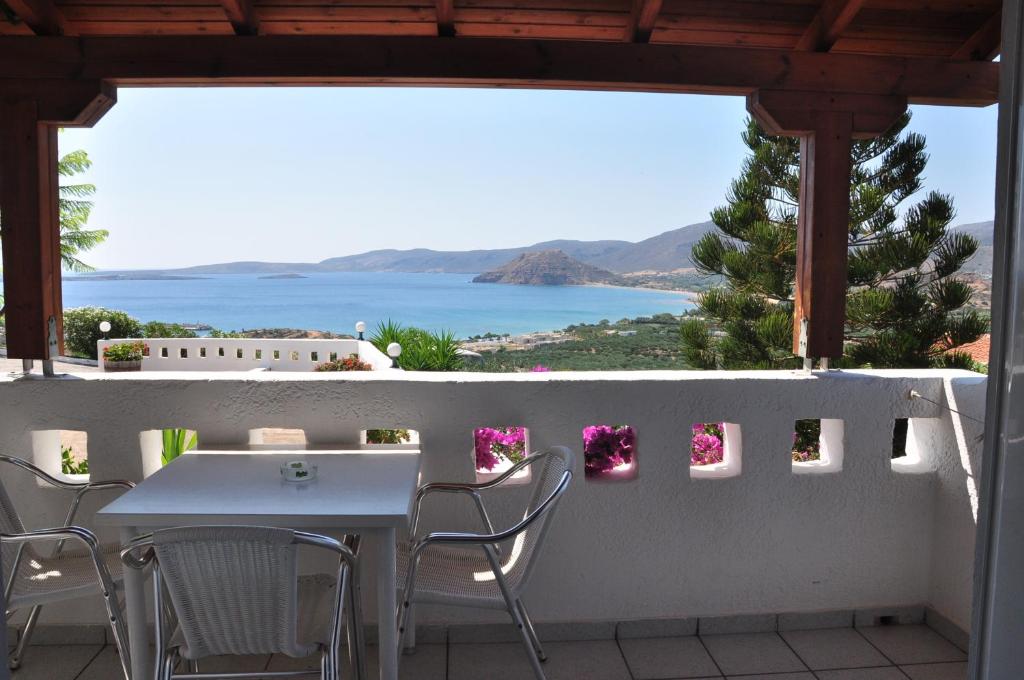 a table and chairs on a balcony with a view of the ocean at Castri Village Hotel in Palekastron