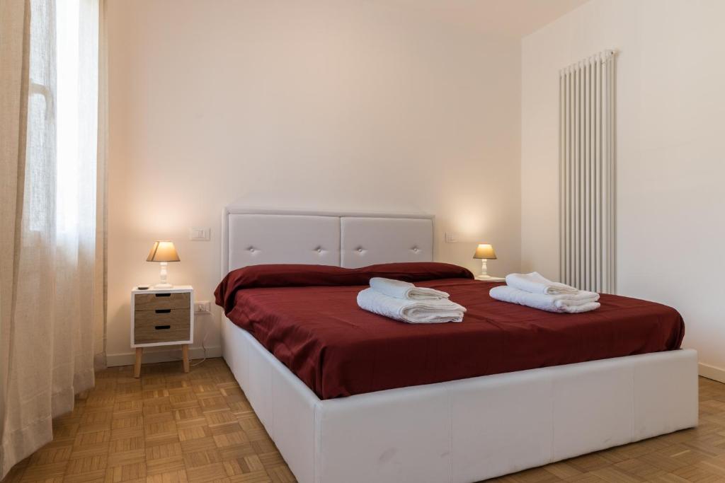 una camera bianca con un grande letto con lenzuola rosse di Treviso modern TOP fittings a Treviso