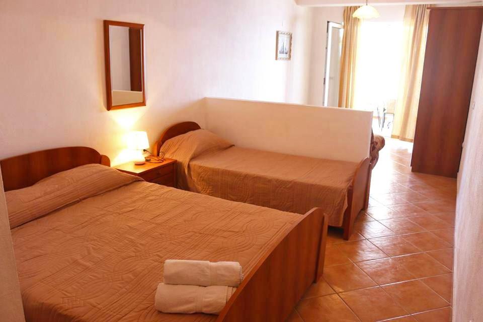 una camera d'albergo con due letti e uno specchio di Apartments Kepi Gjerana a Ulcinj