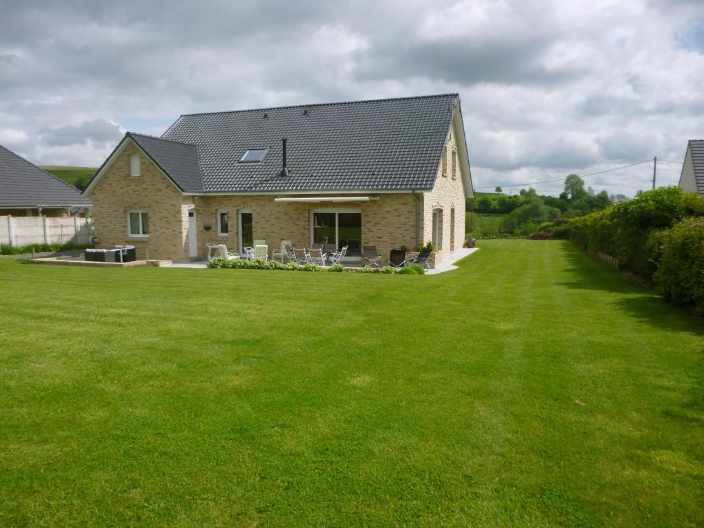 une maison avec une grande pelouse devant elle dans l'établissement Maison de Charme de La Biette, à Bayenghem-lès-Seninghem