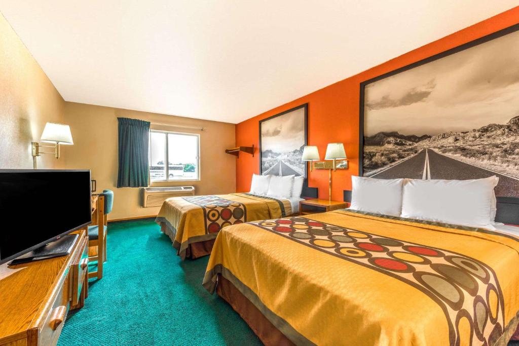 ein Hotelzimmer mit 2 Betten und einem Flachbild-TV in der Unterkunft Super 8 by Wyndham Waco University Area in Waco