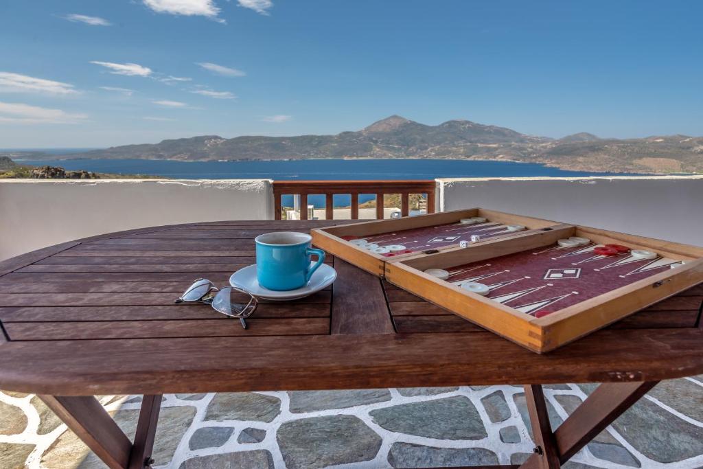 a wooden table with a coffee mug and a cup on a table at Noula House & Studios in Plaka Milou