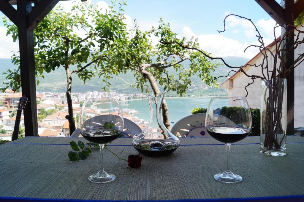 three glasses of wine sitting on a table with a view at Snegar Apartments in Ohrid