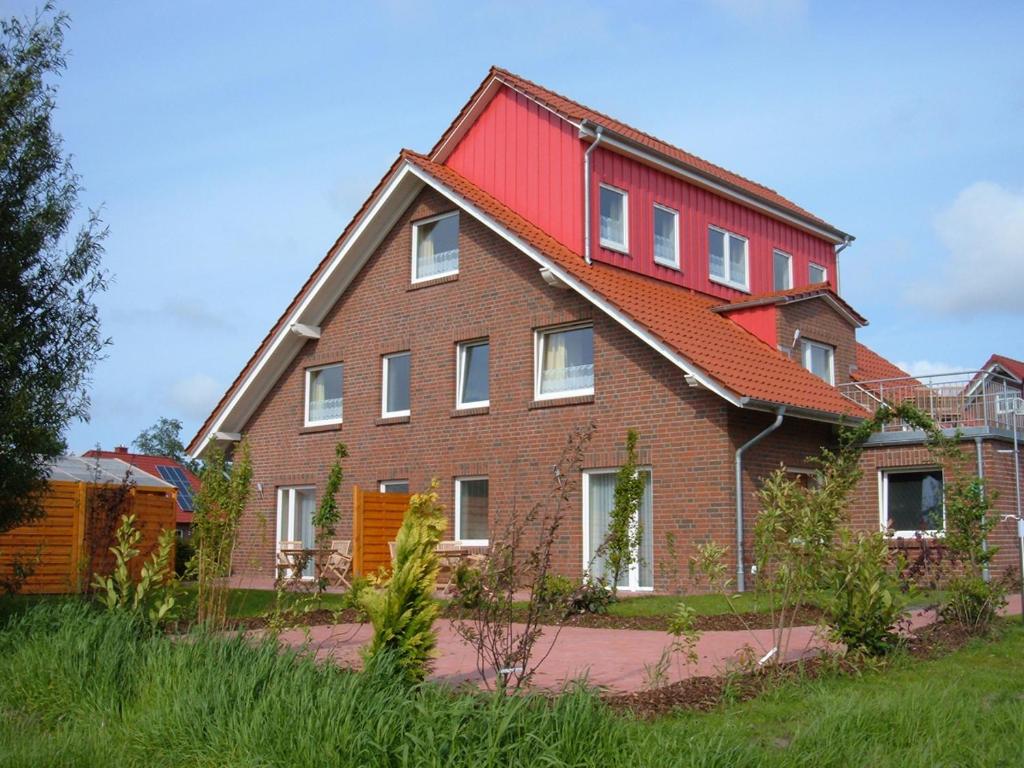 a large brick house with a red roof at Nordsee - Residenz in Dornum