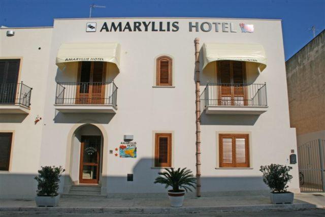 ein großes weißes Gebäude mit Hotelschild drauf in der Unterkunft Amaryllis in San Vito lo Capo