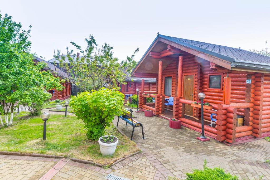 a wooden cabin with a patio in front of it at Частный дом Elisa Sarkau in Lesnoy