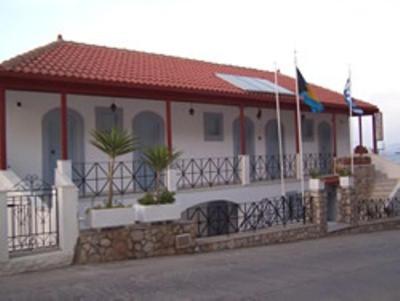 una casa blanca con techo rojo y un edificio en Panorama Hotel en Kalymnos