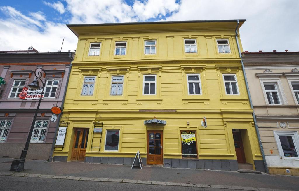 a yellow building on the side of a street at Apartman Centrum in Banská Bystrica