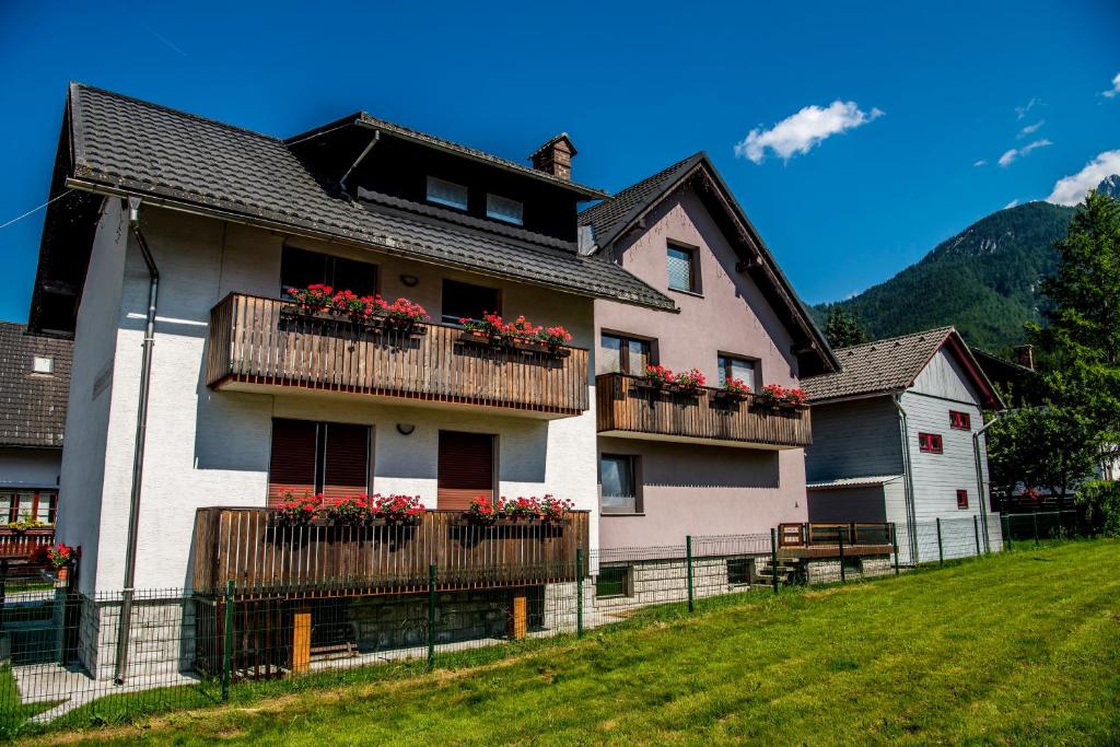 a house with flowers on the balconies of it at Apartments and Holiday Home Grohar in Kranjska Gora