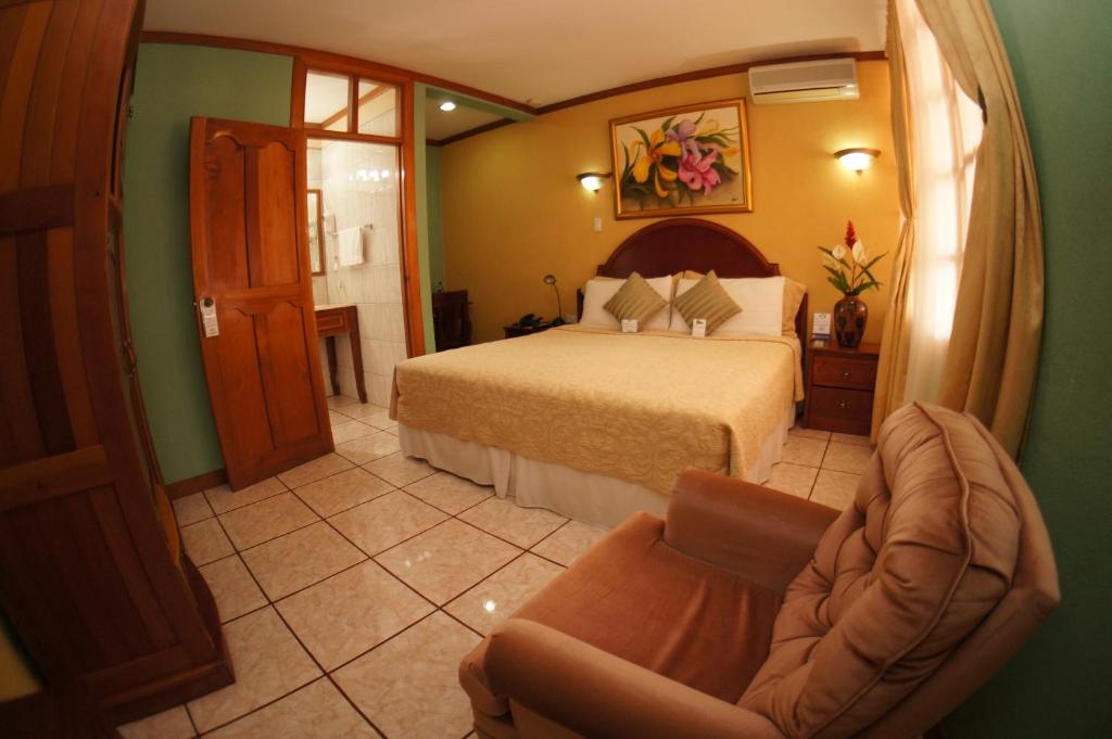Habitación de hotel con cama y silla en Hotel Cafe en Jinotega