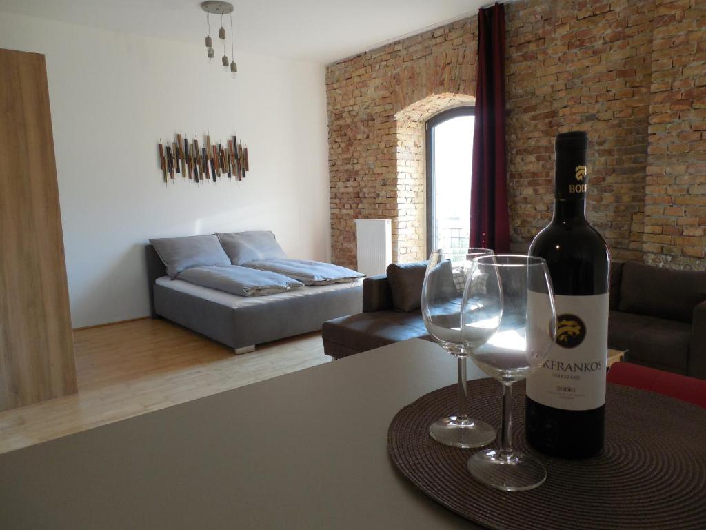 una bottiglia di vino e due bicchieri di vino su un tavolo di The Old Mill Budapest a Budapest