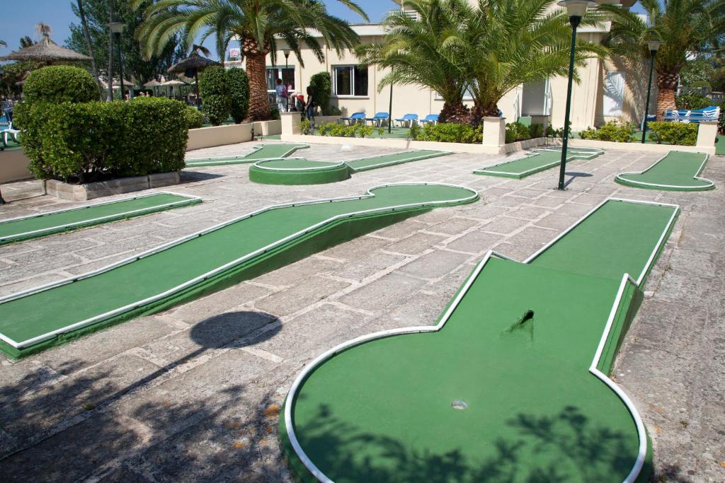 a row of green golf courses in a courtyard at Grupotel Amapola in Playa de Muro
