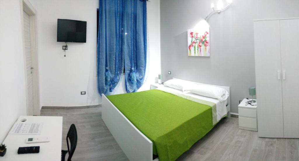 a bedroom with a green bed and a tv at L'angolo di Nina in Vasto