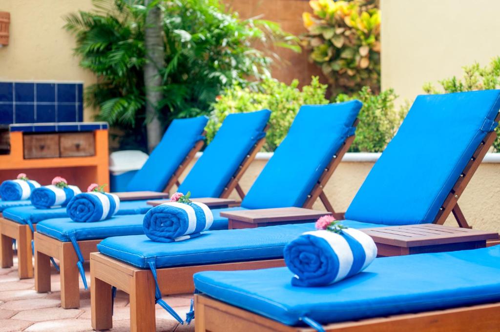 a row of blue chaise lounges on a patio at Abbey Del Sol in Puerto Morelos