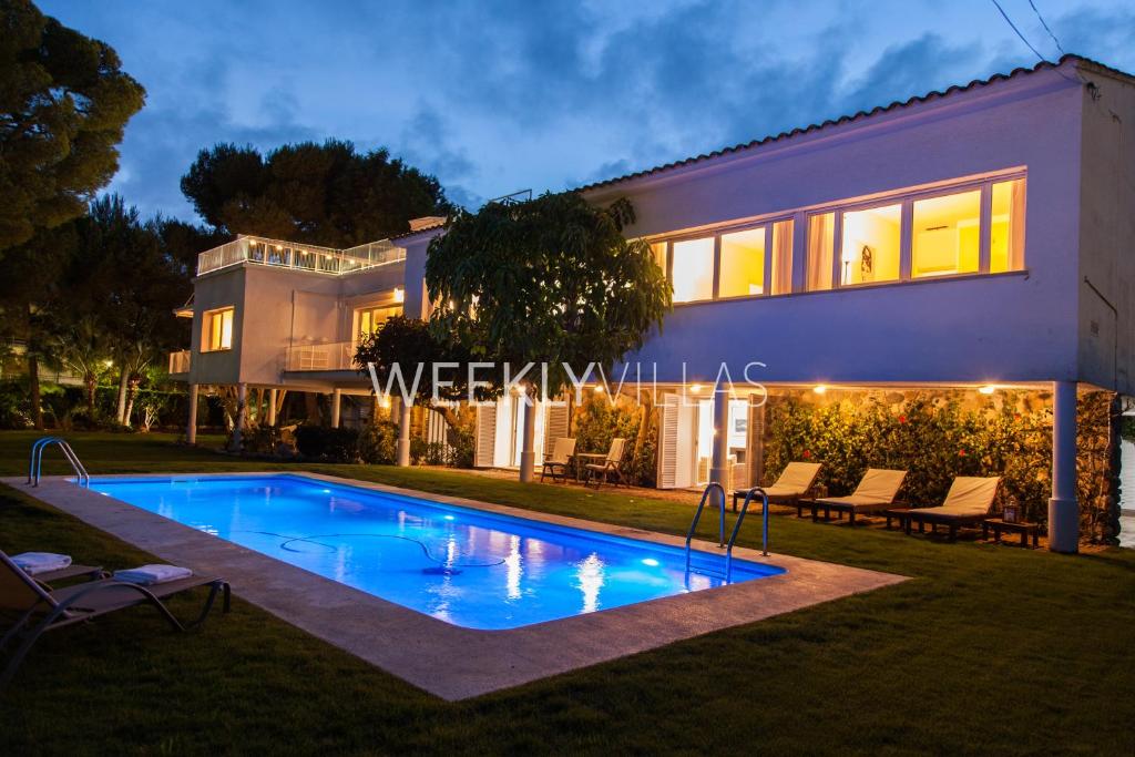 a house with a swimming pool in front of a house at Villa Sitges Tupinetti Beach at 1 min walk Amaizing Garden and View Center Sitges 5 minutes walk in Sitges