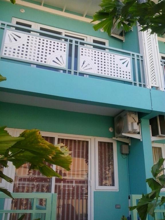 a blue house with a balcony and a door at Ella's Park View Townhouse Crown Point in Crown Point