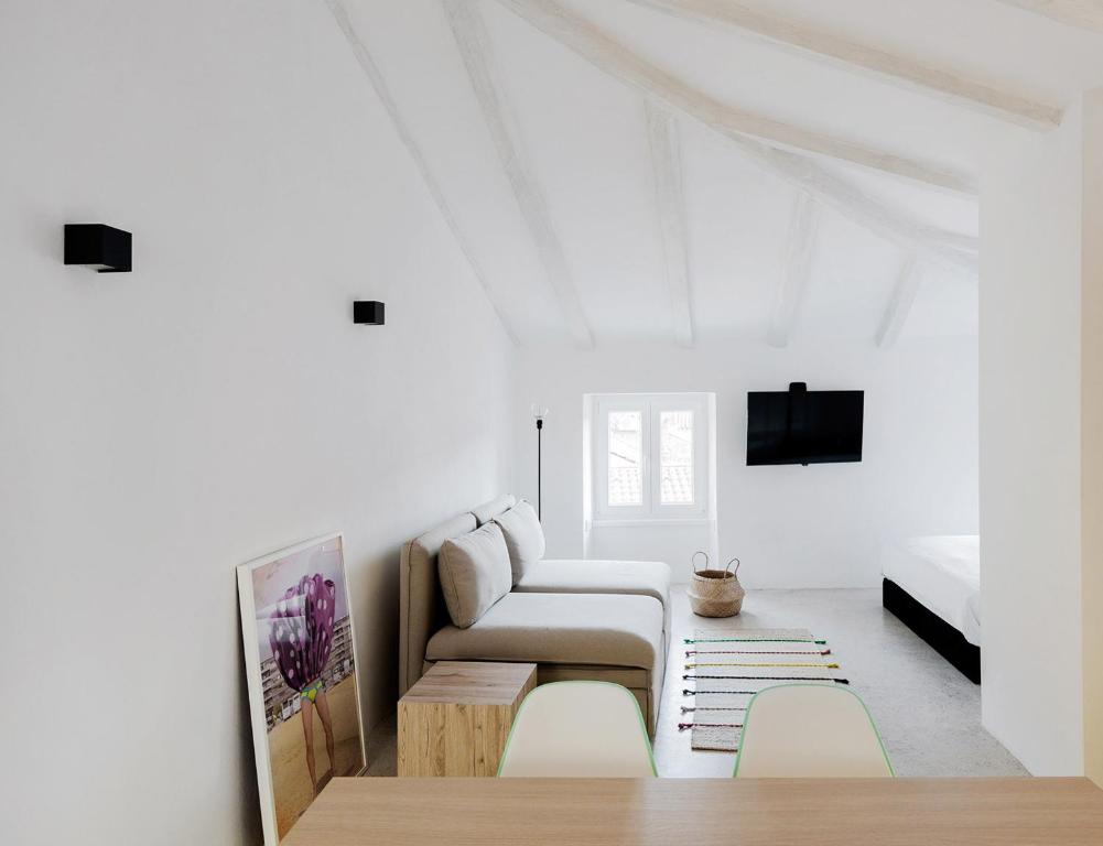 een witte woonkamer met een bank en een tafel bij Labum accommodation in Izola