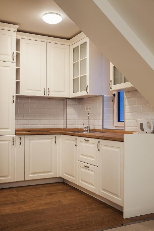 a kitchen with white cabinets and a sink at Castello Boutique Hotel in Čačak