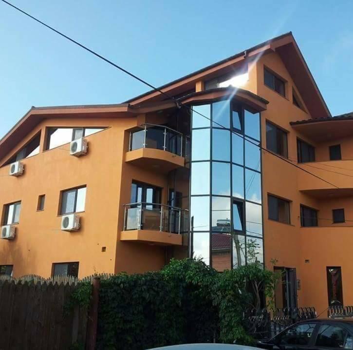 a large building with a glass window in front of it at Pensiunea Casa Beatrice in 2 Mai