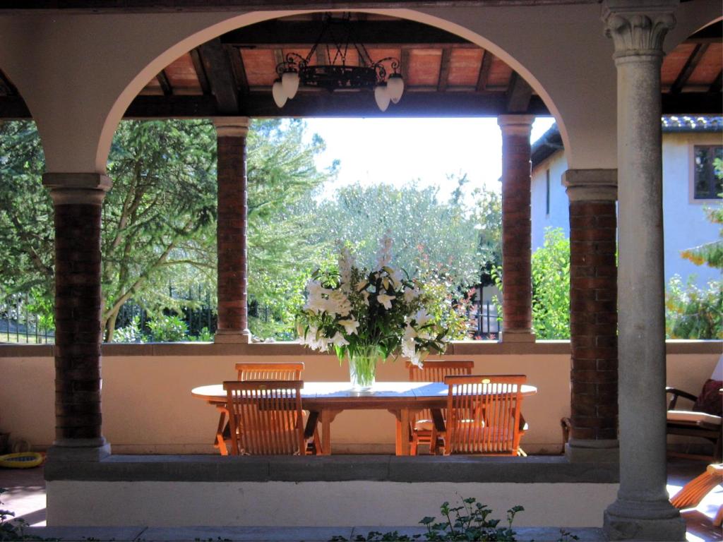 a table with chairs and a vase of flowers at Fiorenza B&B in Florence