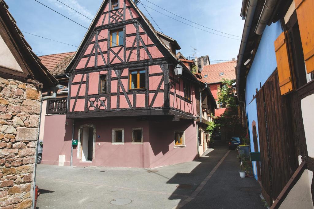 a pink building with a tower on a street at HISSLA ALSACE CHIC&amp; COSY BARR Wine Route in Barr
