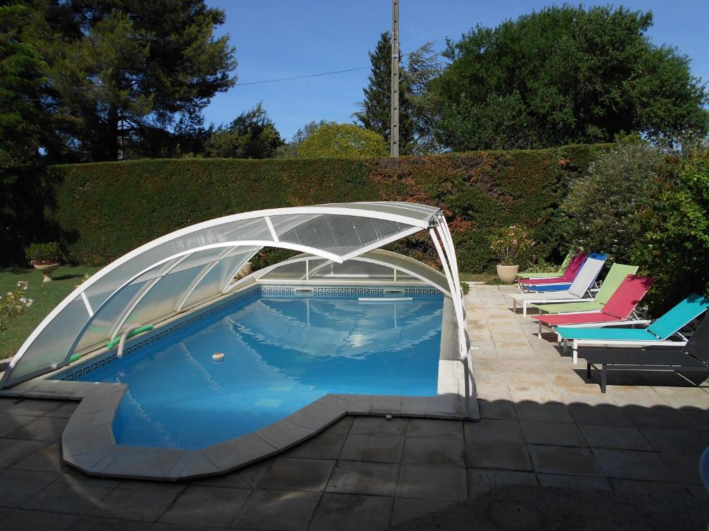 una piscina con cubierta en un patio en Les Tilleuls B&B, en Orange