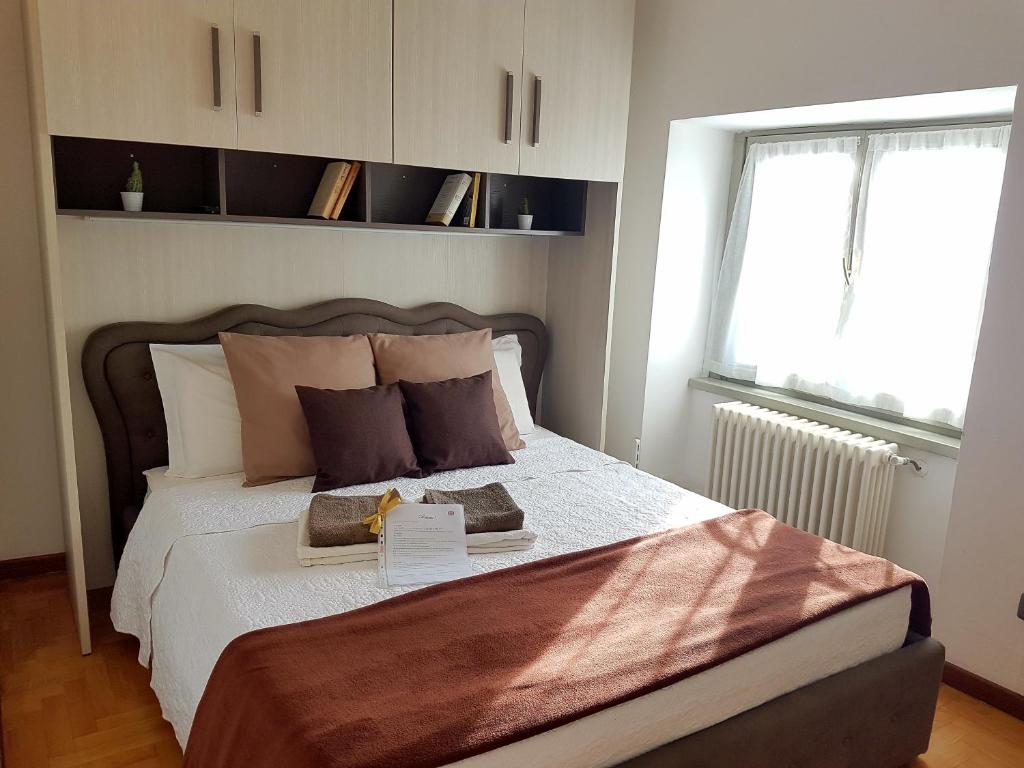 貝加莫的住宿－La Casetta Apartment，卧室配有带枕头的大床和窗户。