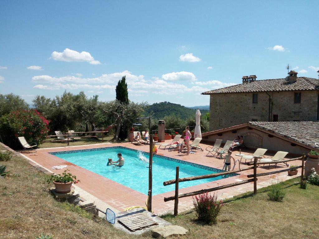 a swimming pool with people in a house at Podere Schioppello Casale con appartamenti privati in Cibottola