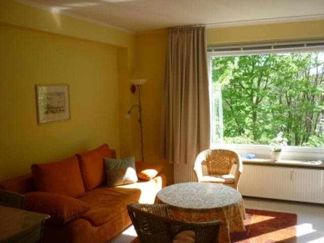 グリュックスブルクにあるFerienwohnung Ostseestrandのリビングルーム(ソファ、テーブル付)、窓が備わります。
