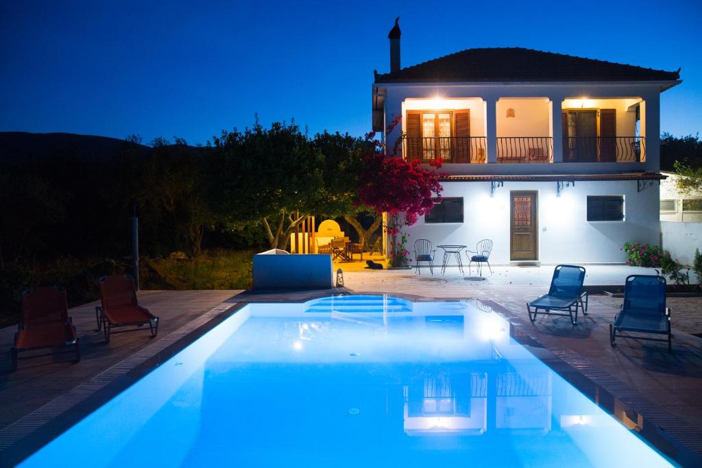 a villa with a swimming pool in front of a house at Villa Lola in Lithakia