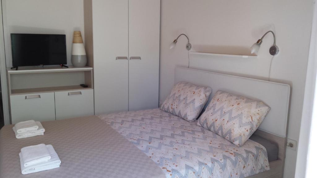 a small bedroom with a bed and a tv at Apartment Dinko in Cres