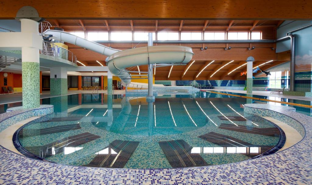 a swimming pool with a slide in the middle at Wellness Hotel Frymburk in Frymburk