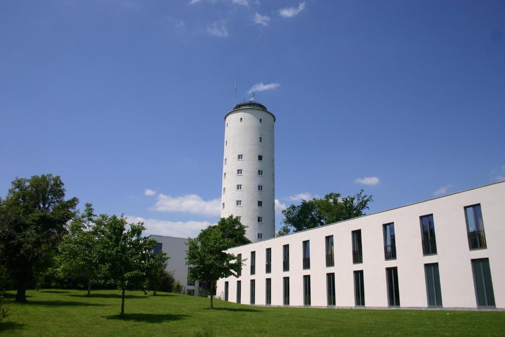 a building with a white lighthouse in the background at Jugendherberge Otto-Moericke-Turm in Konstanz