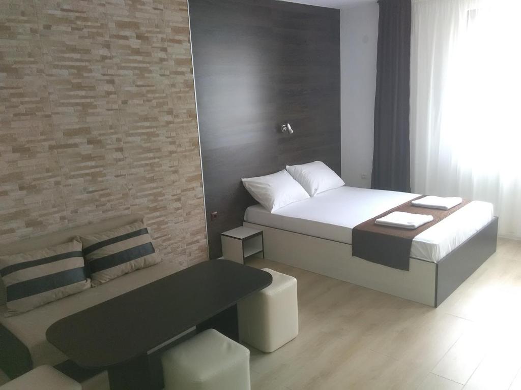 a small bedroom with a bed and a table at Apartments Hristovi in Sandanski