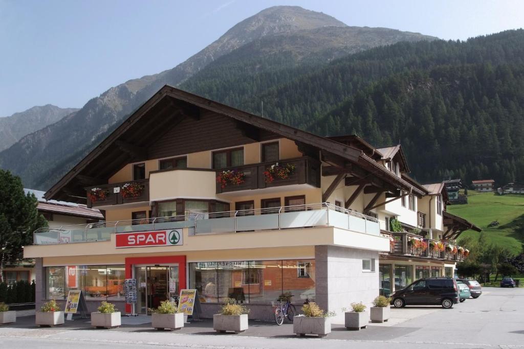 ein Gebäude vor einem Berg in der Unterkunft Appartements Buggl's in Sölden