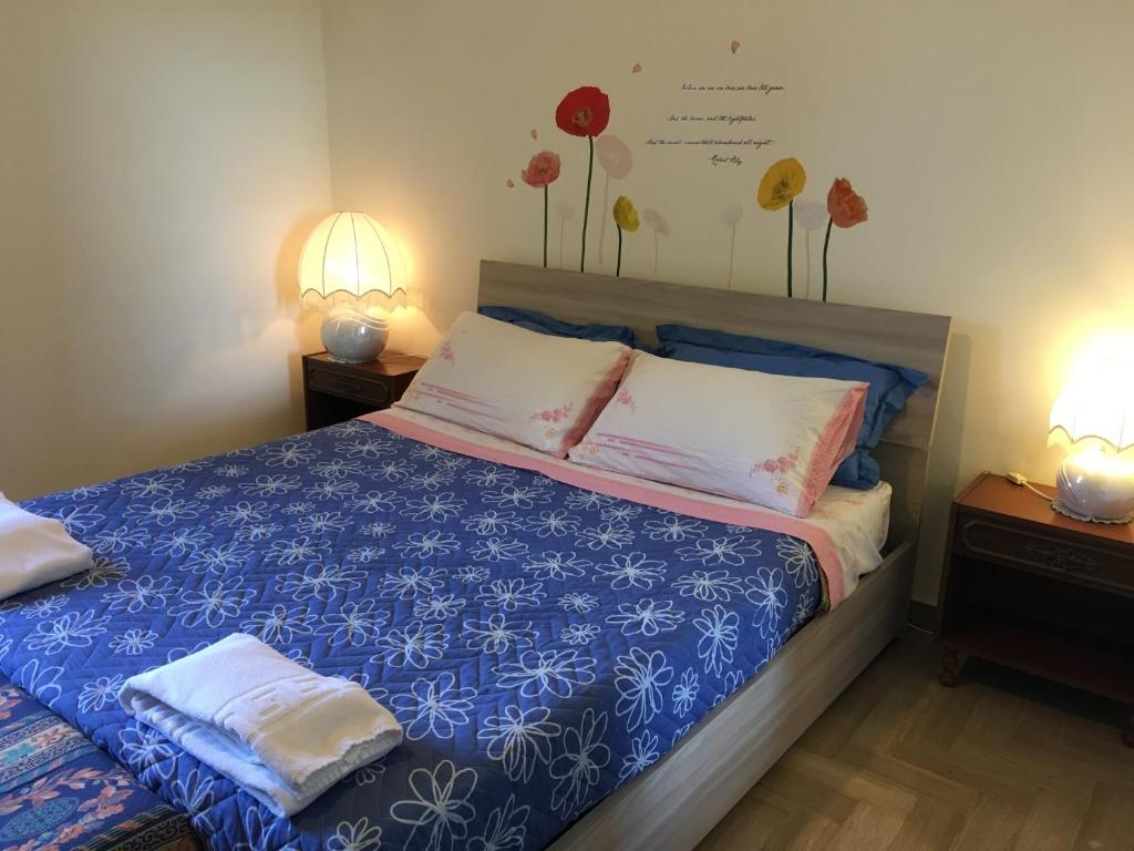 ピティリアーノにあるCasa Cieli di Toscanaのベッドルーム1室(青と白のシーツとランプ2つ付)