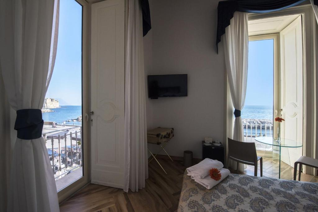 a bedroom with a bed and a view of the ocean at Mareluna Suite de Charme in Naples