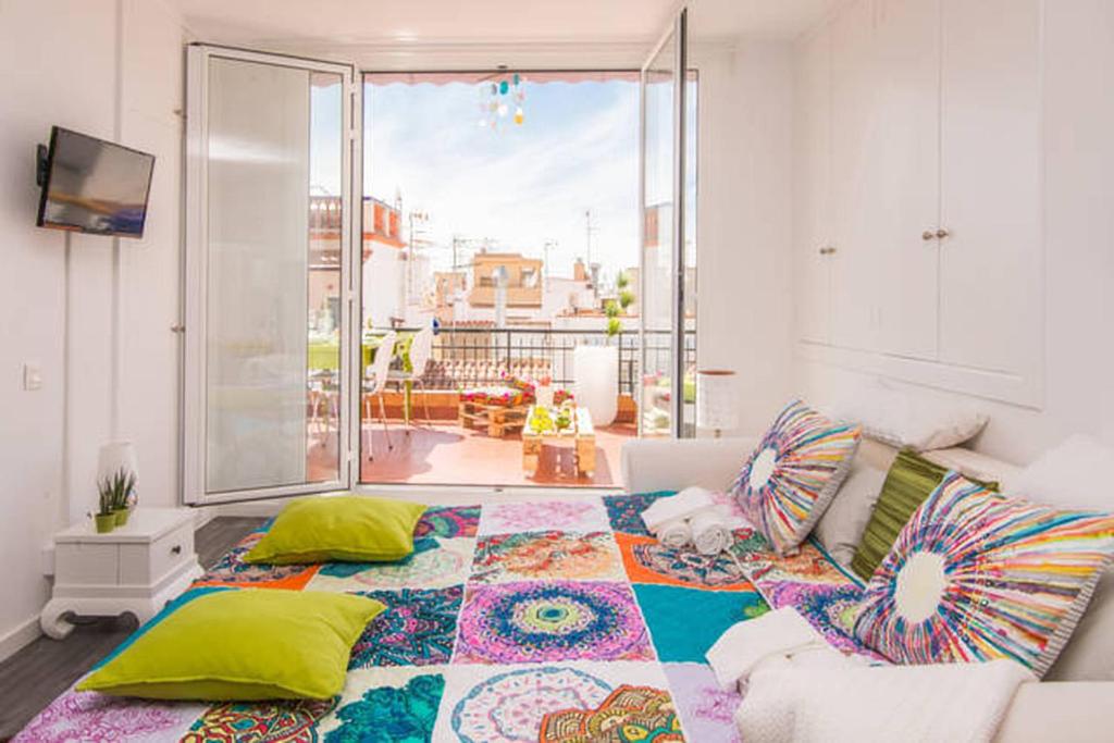 シッチェスにあるUnique studio Apartment with amazing terrace Sitges centre beachのベッドルーム1室(大型ベッド1台、カラフルな枕付)